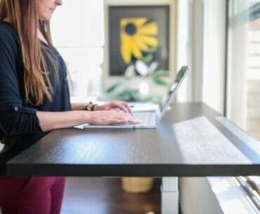 Reasons Why You Should Buy Lift Desk     woman in black shirt sitting at the table using macbook