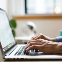 person typing on silver MacBook