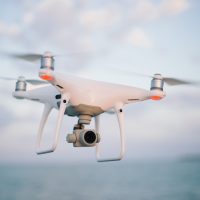 close up photography of drone flying over body of water at daytime