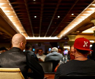 man in black crew neck shirt wearing red cap sitting on chair