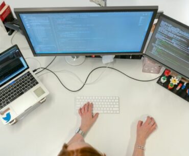 person using macbook pro on white table