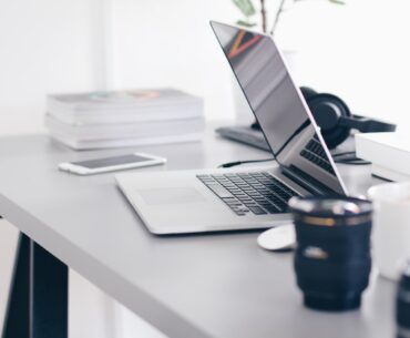 silver MacBook Pro on white table