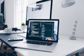 Is Agile a Good Career option? A MacBook with lines of code on its screen on a busy desk