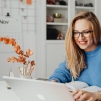 Woman Using Laptop and Smiling