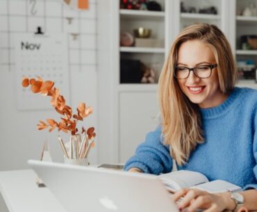 Woman Using Laptop and Smiling