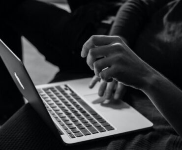 grayscale photo of person using MacBook