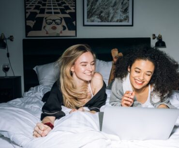 Two Young Women Having Fun While Looking at a Laptop
