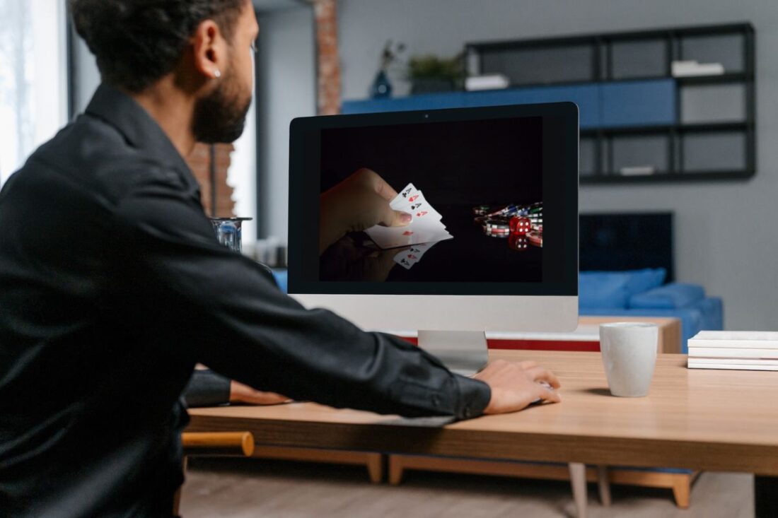A person playing cards on a computer Description automatically generated with medium confidence
