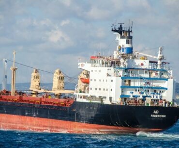 blue and white ship on sea under white clouds during daytime