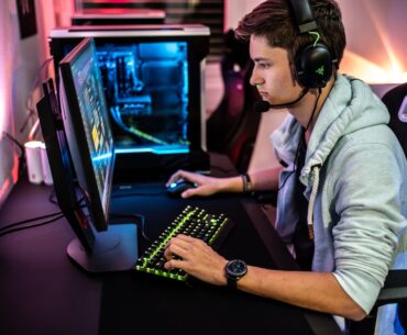 a man sitting at a computer with headphones on