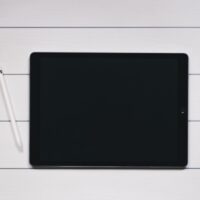 space gray iPad with Apple Pencil with white and black pinstriped background