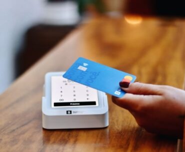 How to Create Professional Invoices with an Invoice Maker Tool a person holding a credit card in front of a machine