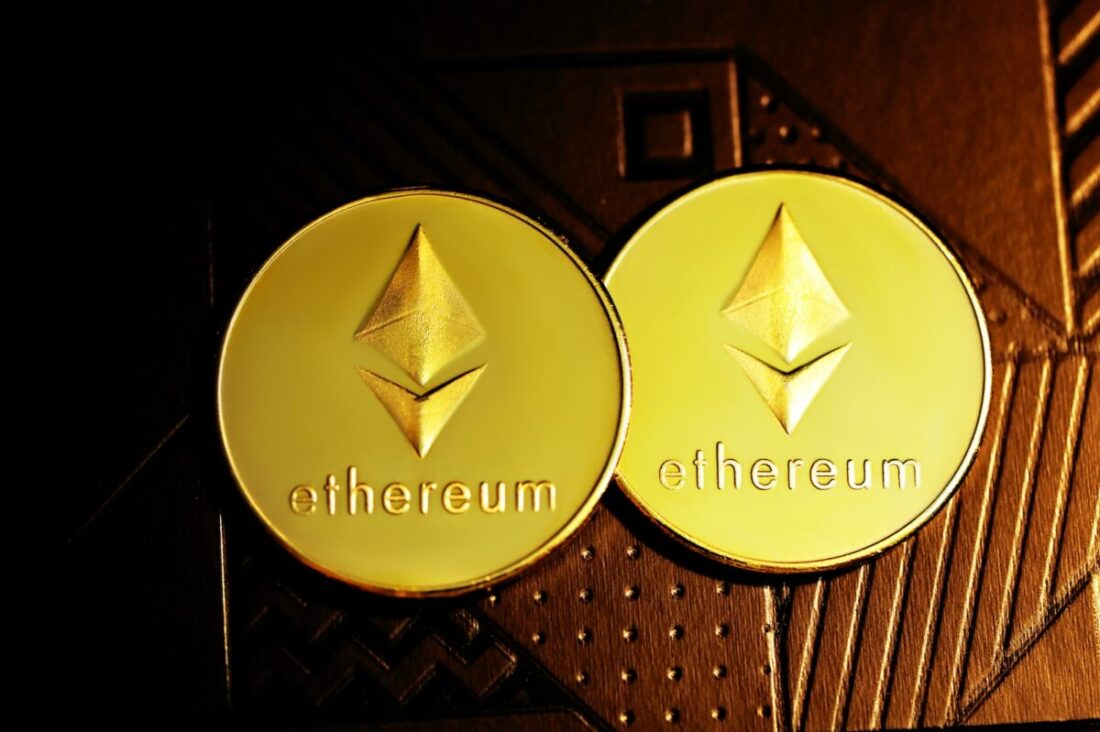 a close up of two gold coin with the word ether on it