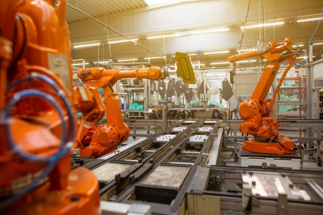 In What Areas is Intelligent Automation Used? a factory filled with lots of orange machines