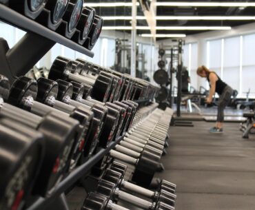 4 Mistakes to Avoid When Marketing for Gyms woman standing surrounded by exercise equipment