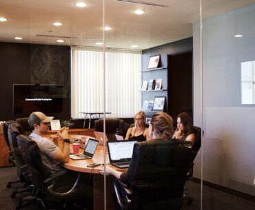 people sitting near table with laptop computer