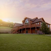 brown wooden house with green grass field