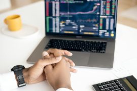 Swing Trading Quotes That Make You Think Differently Close-up of a person analyzing stock data on a laptop with graphs and charts visible.