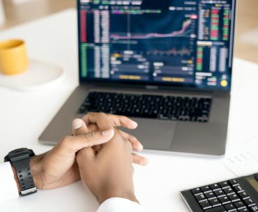 Swing Trading Quotes That Make You Think Differently Close-up of a person analyzing stock data on a laptop with graphs and charts visible.