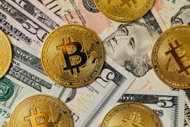 Using a Crypto Debit Card: 5 Tips for Smooth Transactions Golden bitcoins on a background of US dollar bills representing cryptocurrency and traditional money.