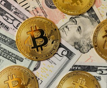 Using a Crypto Debit Card: 5 Tips for Smooth Transactions Golden bitcoins on a background of US dollar bills representing cryptocurrency and traditional money.