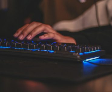 How to Ascend your Path of Exile 2 Character person holding gaming keyboard