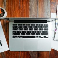 a laptop computer sitting on top of a wooden desk