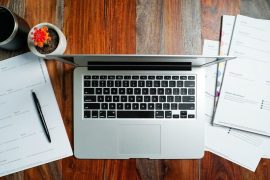 a laptop computer sitting on top of a wooden desk