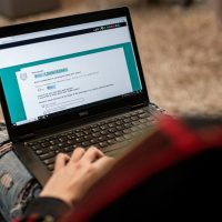 a person sitting on the floor using a laptop