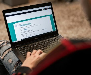 Elevating Your IT Certification Journey with Modern Online Learning Tools a person sitting on the floor using a laptop