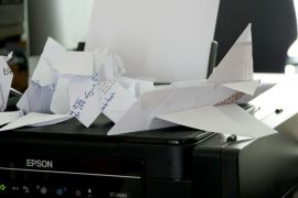 a bunch of papers sitting on top of a printer