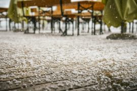 A bunch of tables and chairs covered in snow