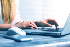 a woman is typing on a laptop computer