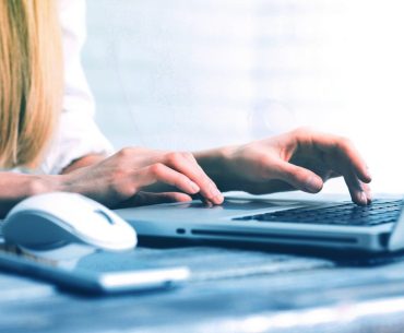 a woman is typing on a laptop computer