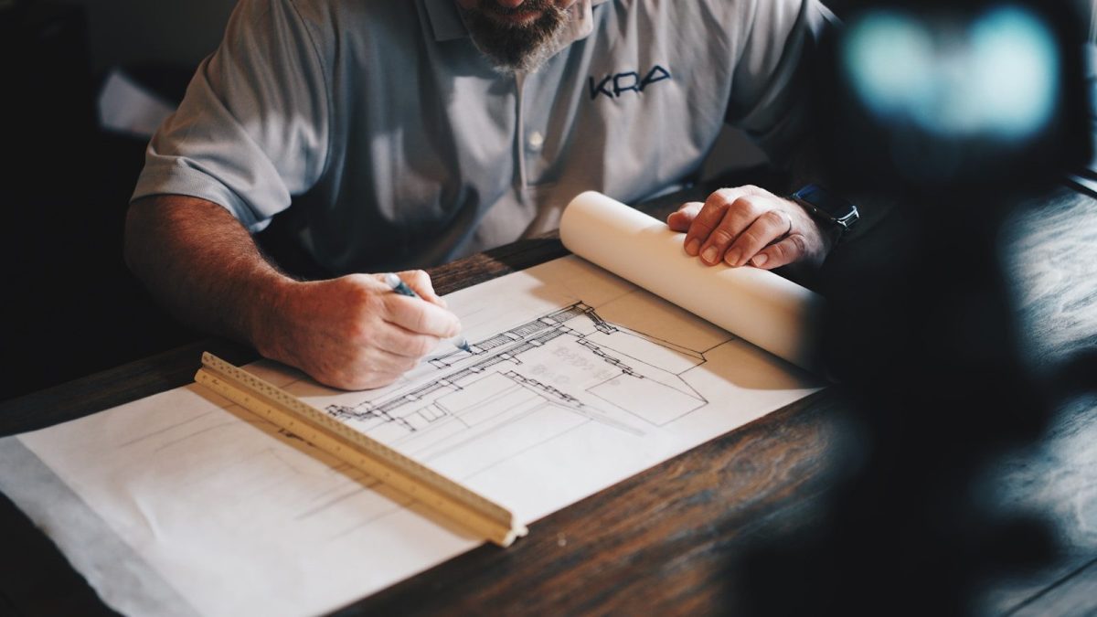 Web Design + SEO: Turning a Malaysia Engineering Firm’s Site Into a Lead Engine An architect working on a draft with a pencil and ruler
