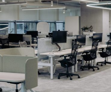 Creating Safer Workspaces Through Technology an office with a lot of desks and chairs