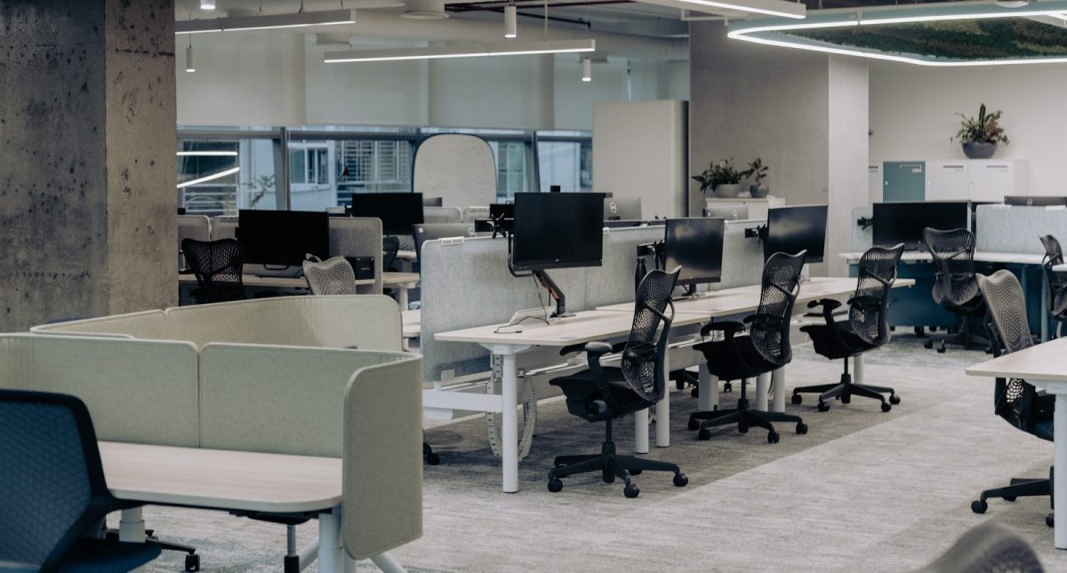 Creating Safer Workspaces Through Technology an office with a lot of desks and chairs