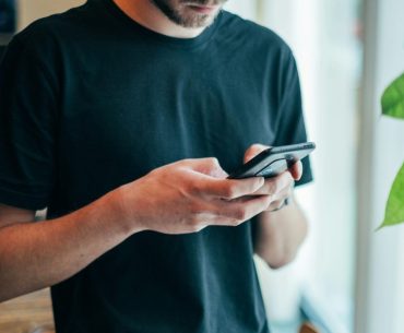 Best Crypto Casinos to Play Mines man in black crew-neck top using smartphone