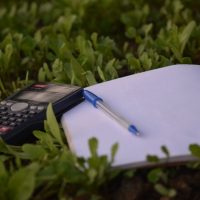 blue ballpoint pen on paper beside calculator